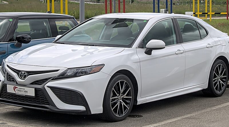 Toyota Camry màu trắng đỗ tại bãi xe.